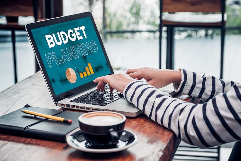 Close up hand of influencer budget planning for online media advertising at cafe restaurant.online marketing concept