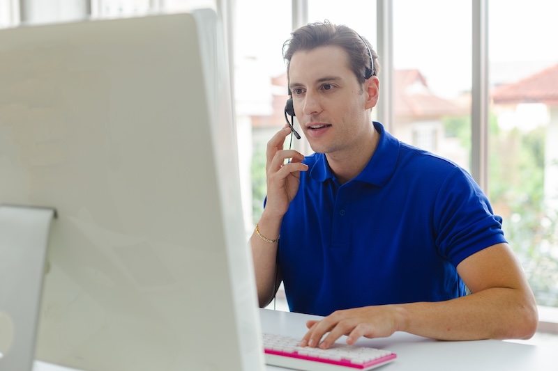 CallMiner Man operators with microphone and computer at work, Call center, support telemarketing.